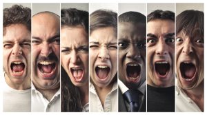 Seven people expressing intense emotions, mouths open.