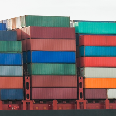 Stacked colorful shipping containers at port.