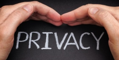 Hands protecting the word "privacy" on chalkboard.