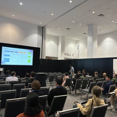 Conference presentation in Hall C with attendees.