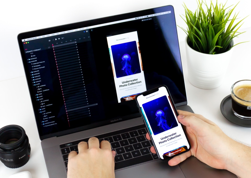 Person comparing a mobile app with its desktop version on a laptop.
