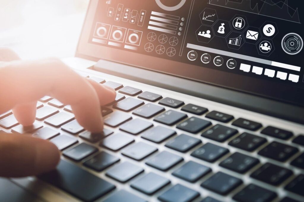 Person typing on a laptop with digital security icons on the screen.